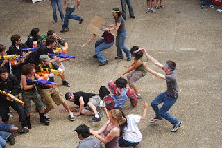 A wave of zombies rushes towards a group of humans standing their ground